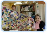 Two IDEAs members with a  patchwork quilt.